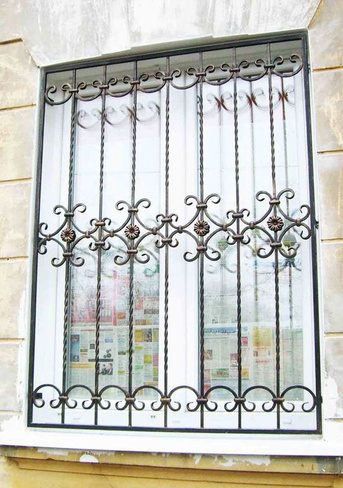 Решетка на окно с кованым узором из бубликов, перетянутых хомутами