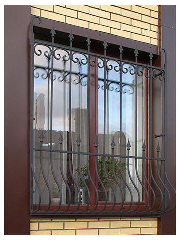Решетка на окно, украшенная двумя рядами кованых пик Черная